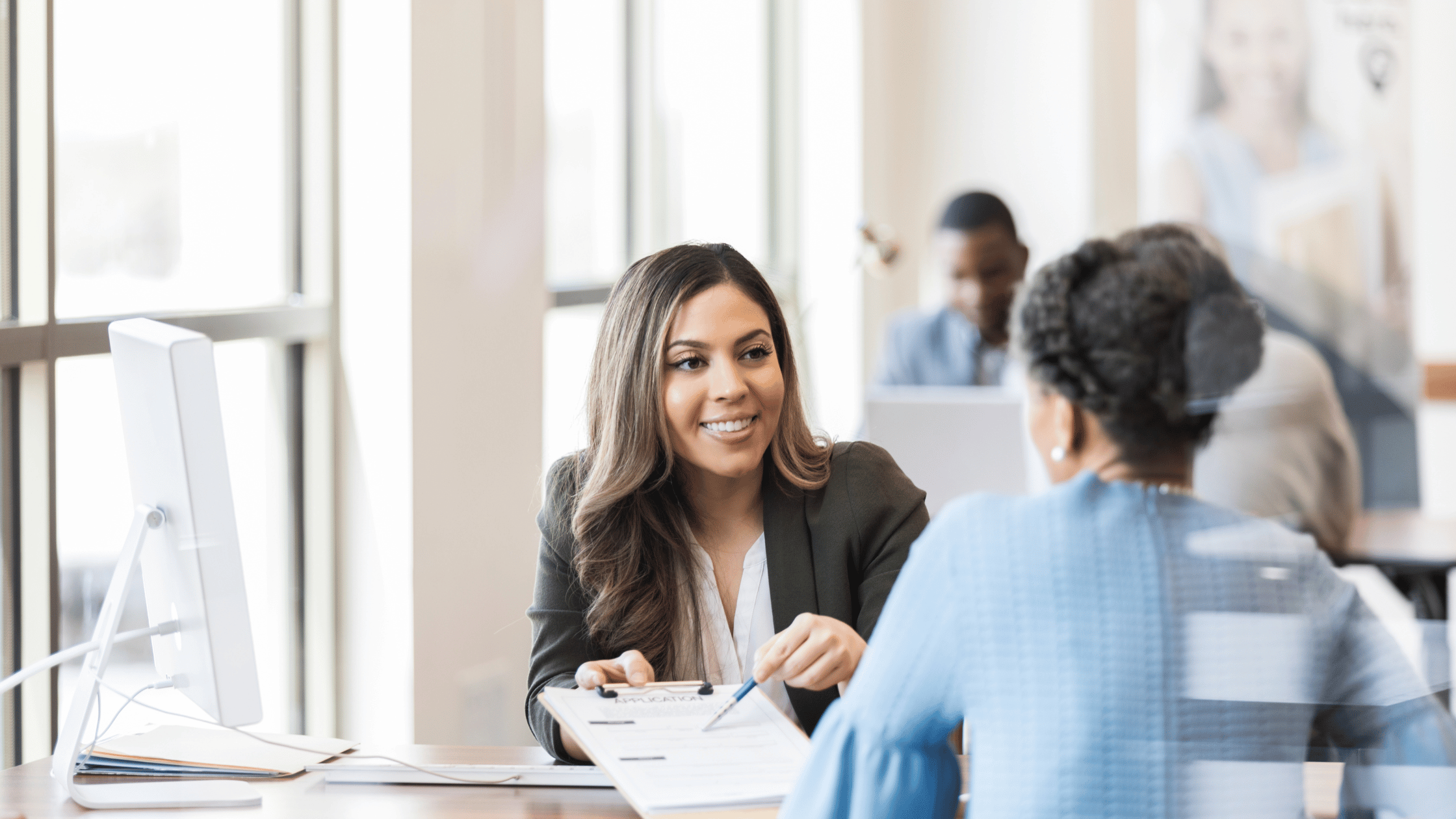 banker helping a person fill out a form