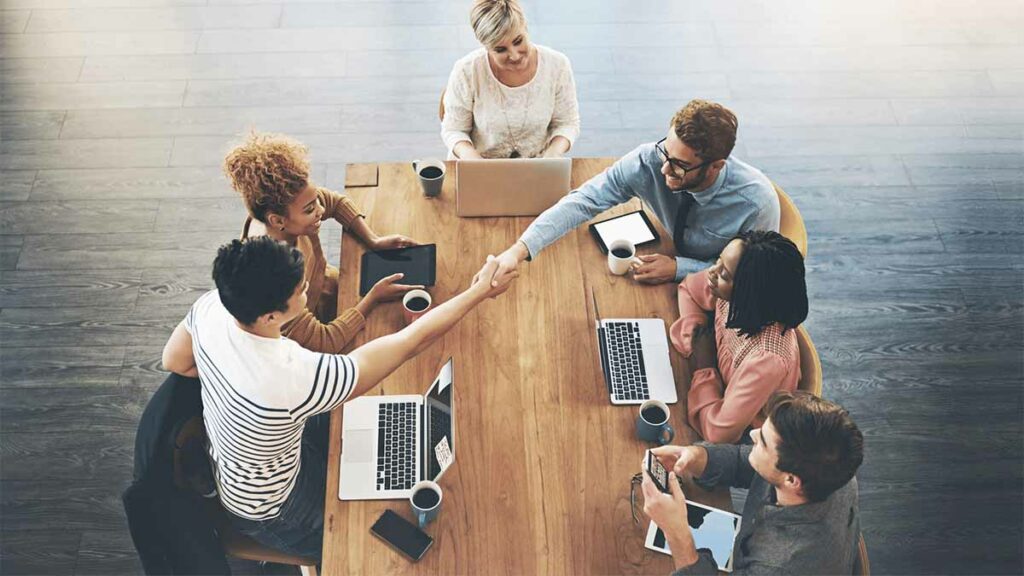 Team having a meeting sitting around a table.