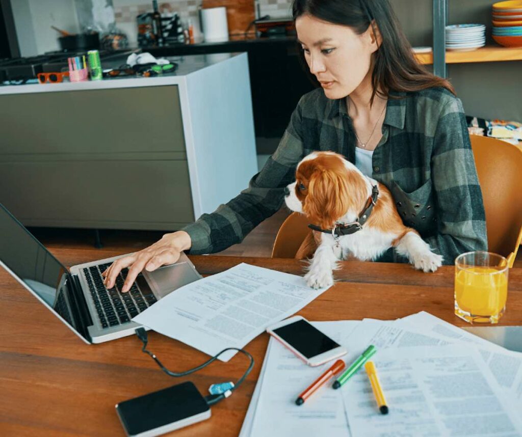 Woman sitting at work desk with puppy