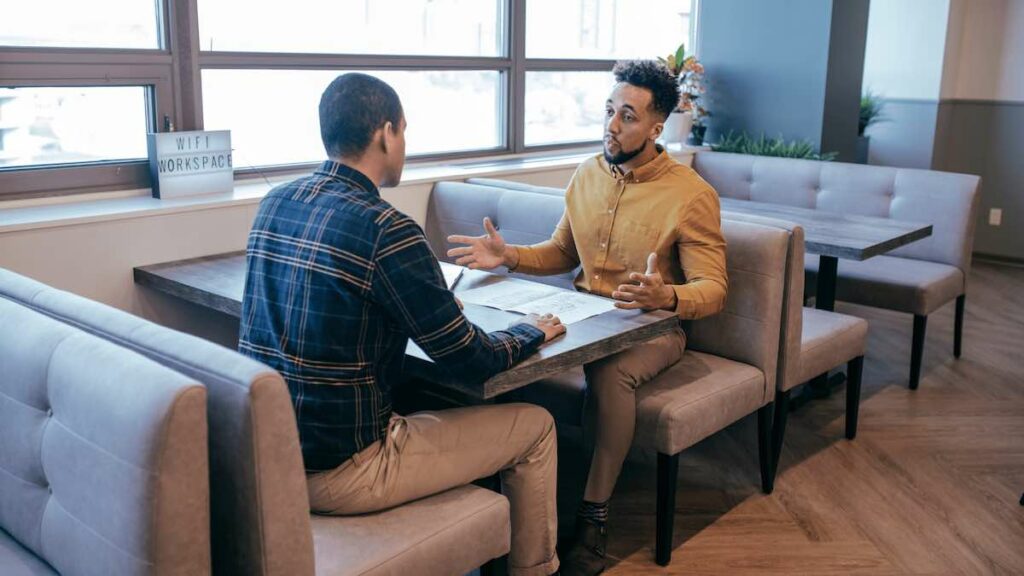 Two men sitting at a table having a work conversation