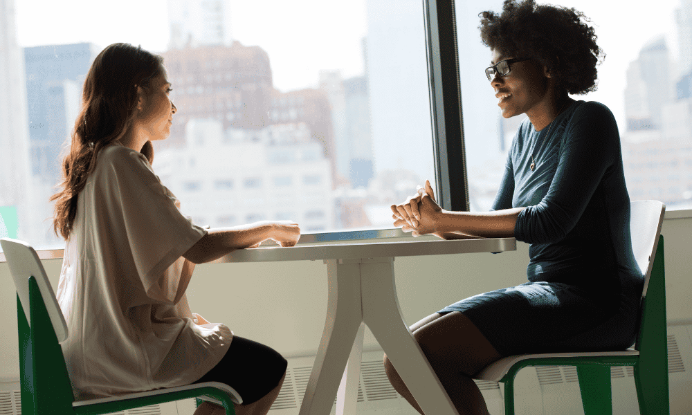 two people sitting at a table having a conversation