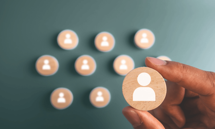buttons with people icons on them with a hand picking up one of them